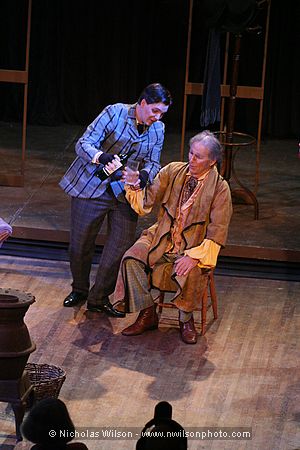 Schaunard pours liquor for landlord Benoit (Richard Goodman, baritone) who has come to collect the rent.
