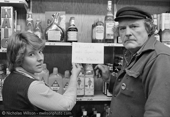 Byrd Baker (r) and clerk at Mendocino's liquor store show a sign reading "No sake until Japan stops killing whales."