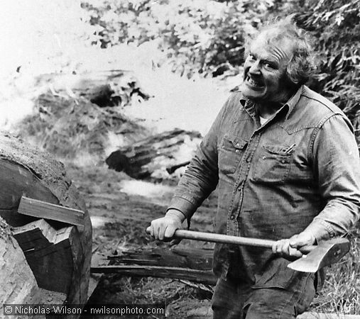 Mendocino sculptor Byrd Baker uses a splitting maul to rough out a redwood log while carving a whale sculpture.