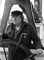 Byrd Baker poses at the helm of the C.A. Thayer, an old-time lumber schooner on display at the Maritime Museum, Hyde St. Pier, San Francisco CA