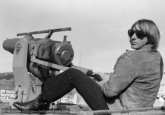 Bob McMillen poses with a whale harpoon cannon on the Sioux City, a former whaling ship, in Richmond CA circa February 1976.