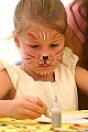 Girl with painted face doing silk hoop painting