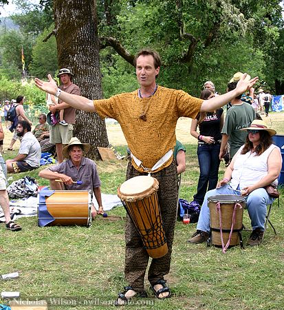 Kim Atkinson leads a drum and rhythm circle including Grateful Dead drummer Mickey Hart seated behind him.