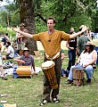 Kim Atkinson leads a drum and rhythm circle including Grateful Dead drummer Mickey Hart seated behind him.