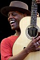 Eric Bibb performs with the Campbell Brothers and flashes a great smile at Carl Campbell, the drummer.