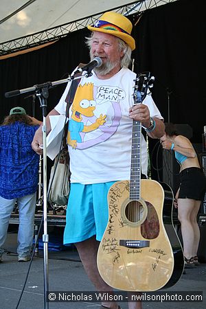 Wavy Gravy shows the guitar signed by many players which was raffled as a benefit for Seva Foundation's work against blindness