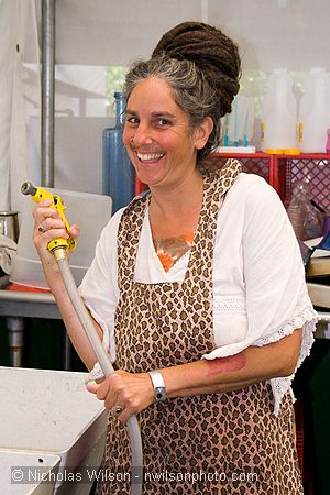 Terri with a water hose and an impish look in the backstage kitchen