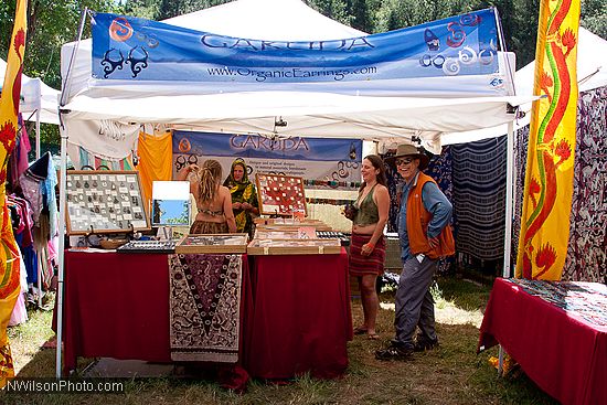 Craft vendor booths line the sides of the main concert meadow