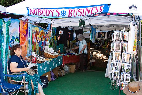 Craft vendor booths line the sides of the main concert meadow