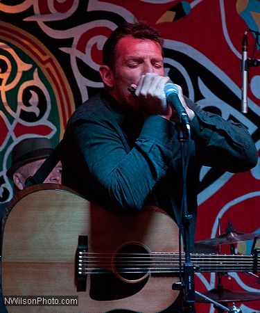 Catfish Jack blows harp at The People's Stage late Saturday night