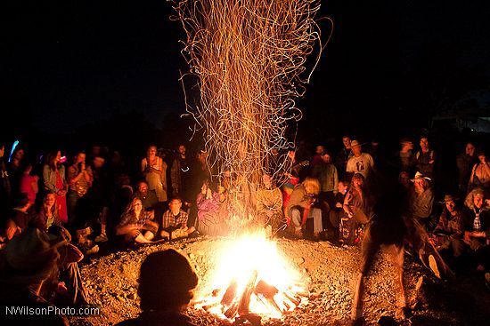 A shower of sparks rises whenever another piece of wood is tossed on the fire.