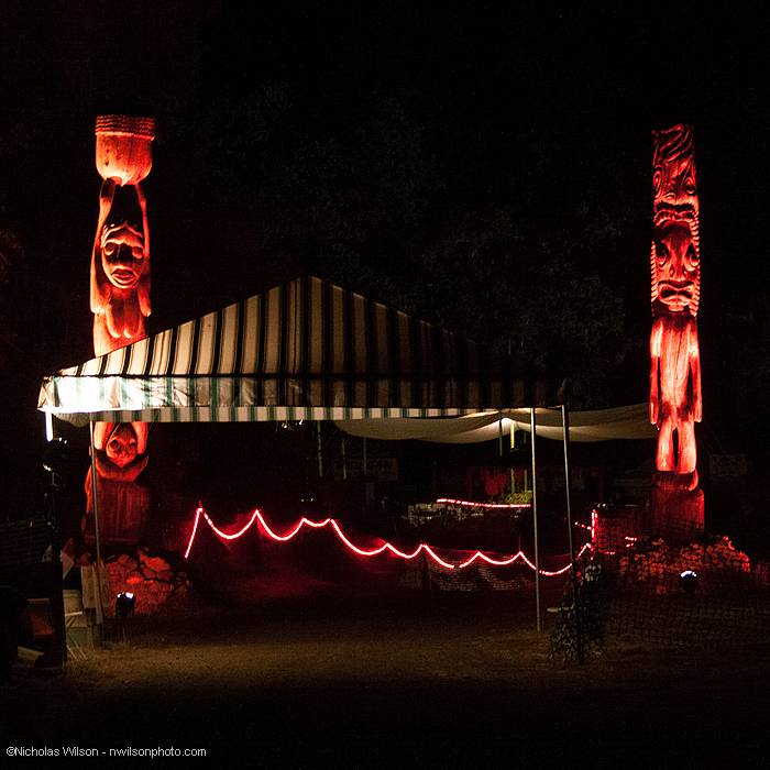 Illuminated tiki poles mark the path to the main concert bowl from the parking area.