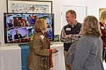 Board members chat in front of a flat screen TV displaying photos from past seasons of the Mendocino Film Festival.