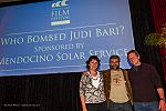 Producer Darryl Cherney in front of the screen with Maggie Watson and Bruce Erickson, owners of the company that sponsored the showing of Who Bombed Judi Bari?