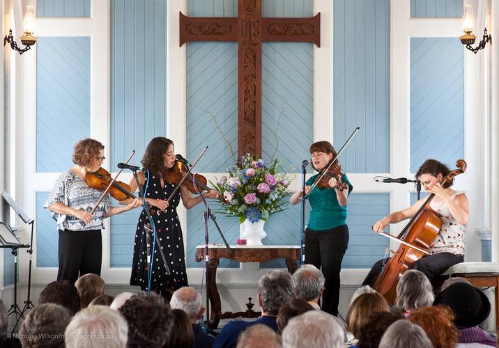 The Real Vocal String Quartet singing and playing.