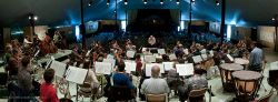 Panoramic view from rear of orchestra in rehearsal for the final concert.