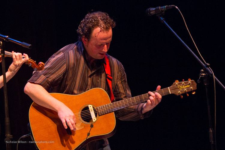 Eamon McElholm plays guitar with Solas.