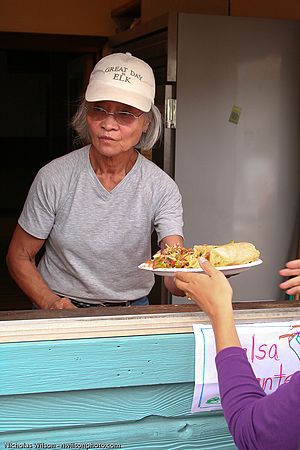 Sachiko serving food from the kitchen window.