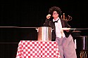 In a wonderful gag, Bill Irwin has stretched a very long piece of spaghetti around through the wings, across the back of the stage, and back to the cook pot in his performance at Cotton Auditorium, Fort Bragg CA