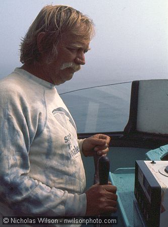 J.D. Mayhew steers the Phyllis Cormack and watches the radio direction finder he brought along.